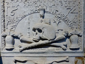 A grave makrer showing a skull and crossbones